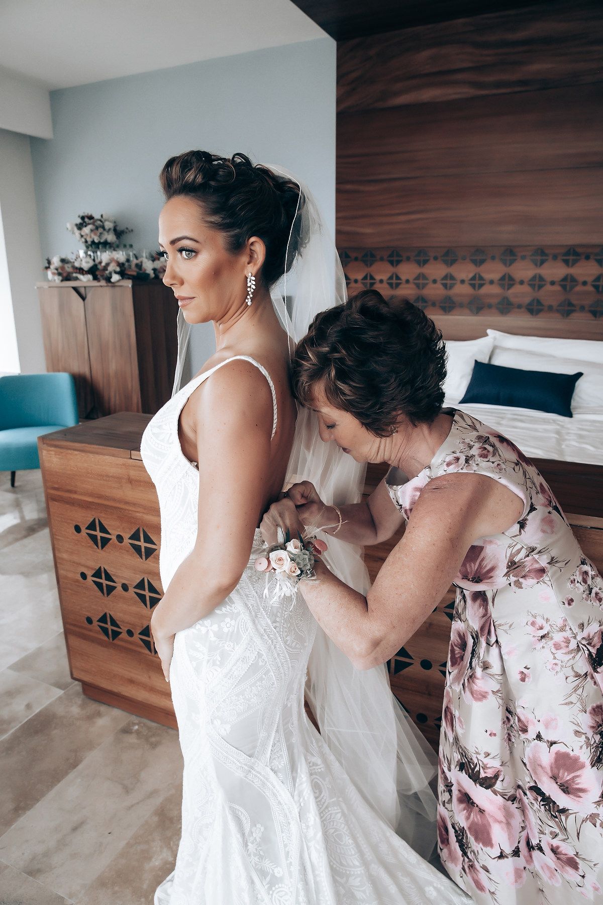 A sequence showing the process of lacing up a white wedding dress with floral details.