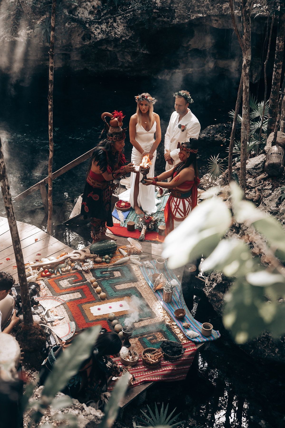 Group gathered around colorful blankets during an outdoor spiritual ceremony.