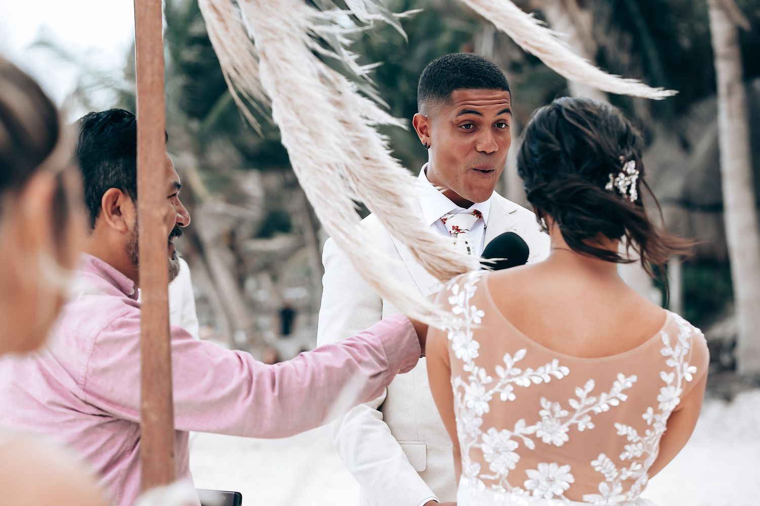Wedding party celebrating with white flower petals being tossed in the air at an outdoor ceremony.