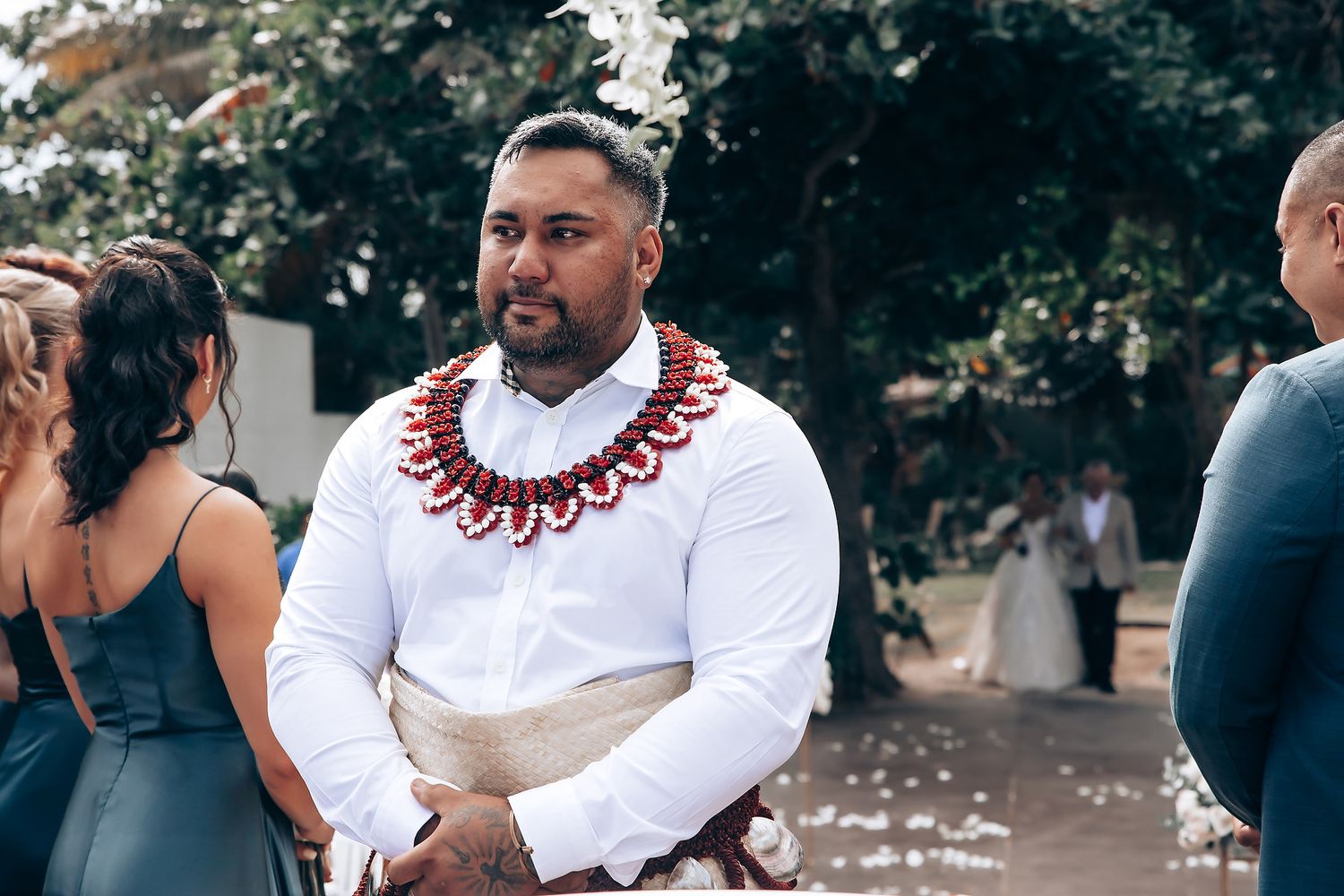 Wedding ceremony moment showing traditional African formal wear with red accents.