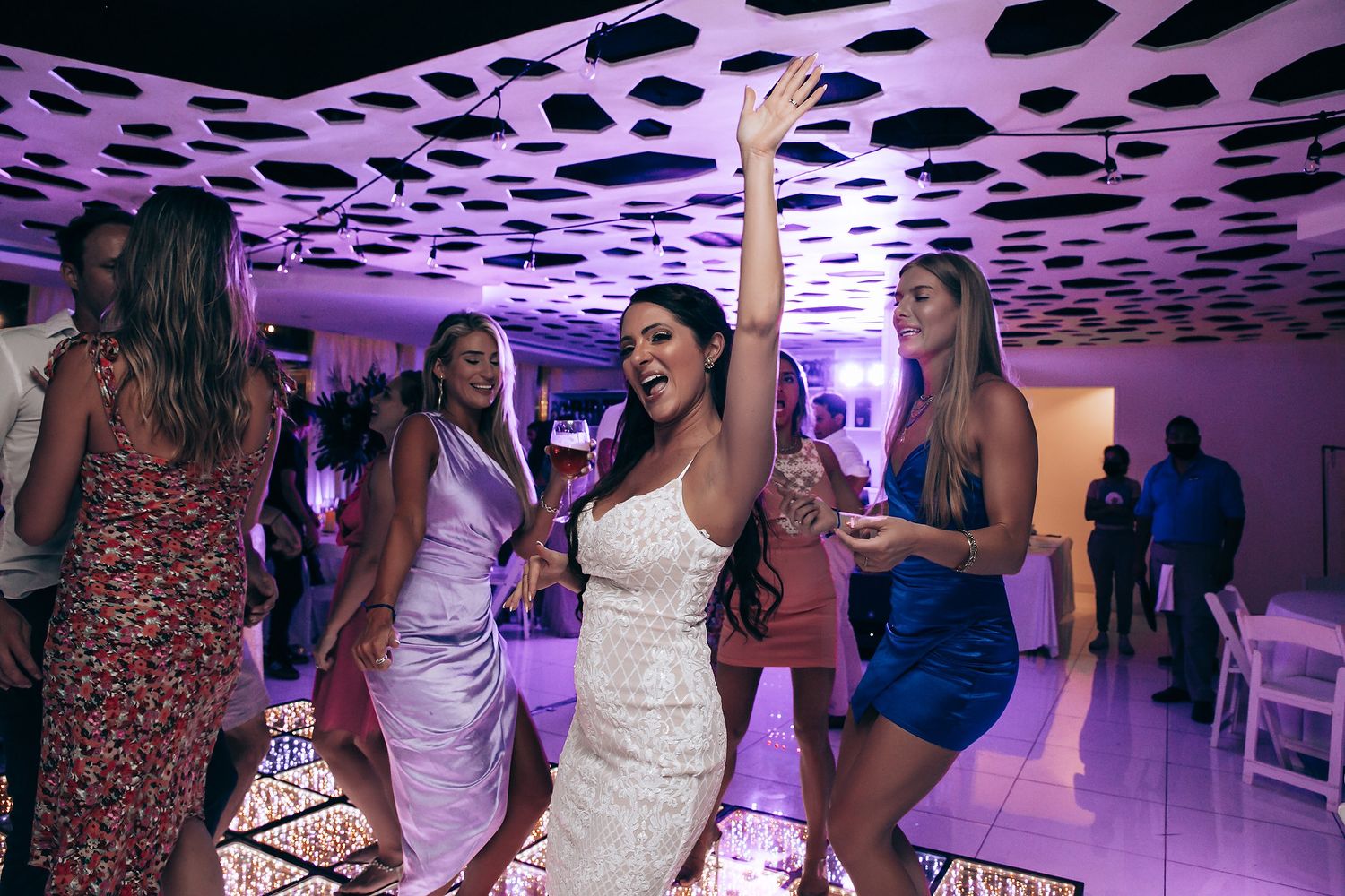 Wedding reception dance floor with spotted purple lighting and celebration atmosphere.