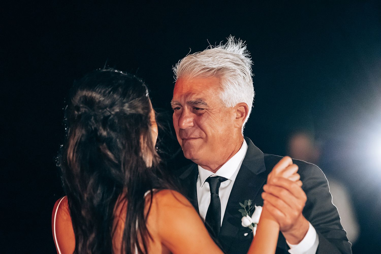 Formal wedding reception dance with guests in elegant attire.
