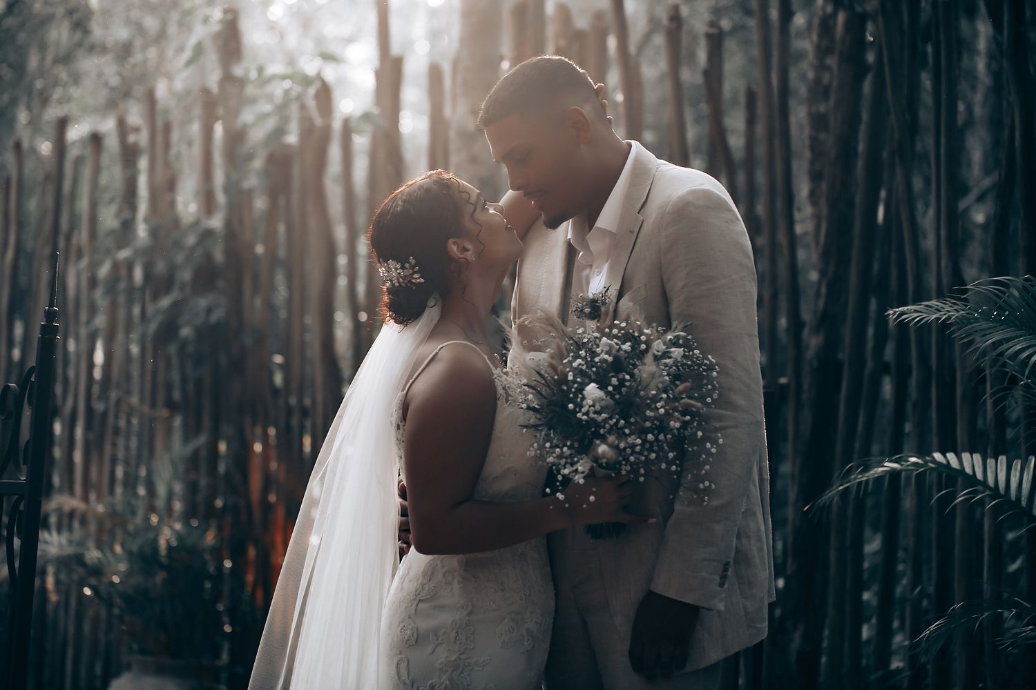 Romantic wedding portraits taken in a moody forest setting with dramatic lighting.