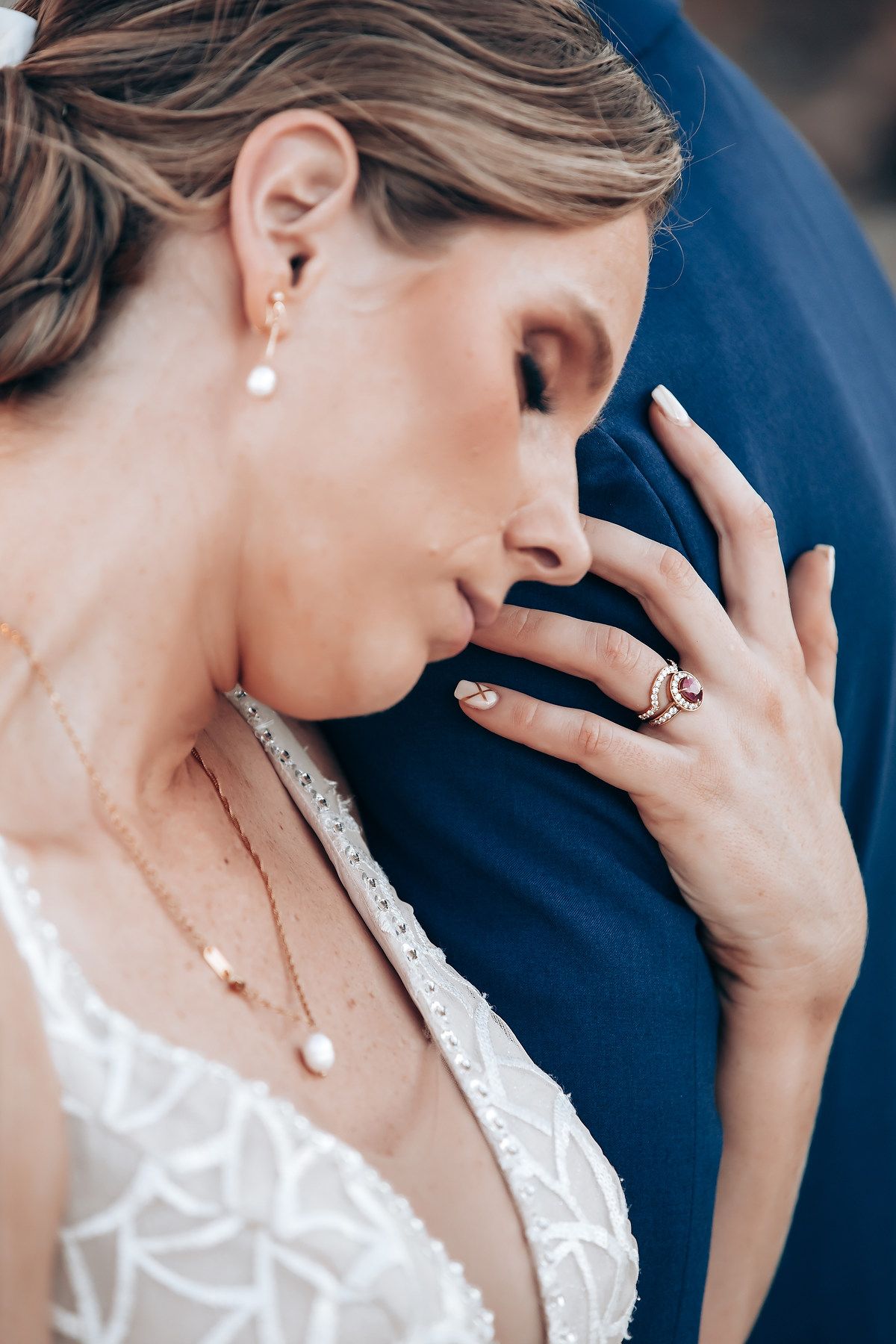 Close-up portrait of a woman with blonde hair and pearl earrings, thoughtfully gazing away.