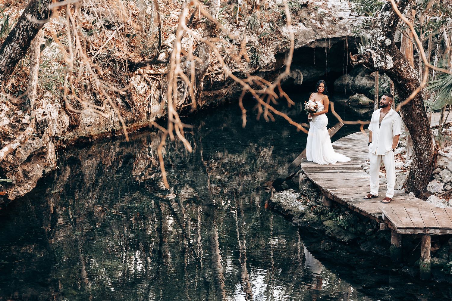 Wedding ceremony location at a scenic cenote with wooden platforms and natural rock formations.
