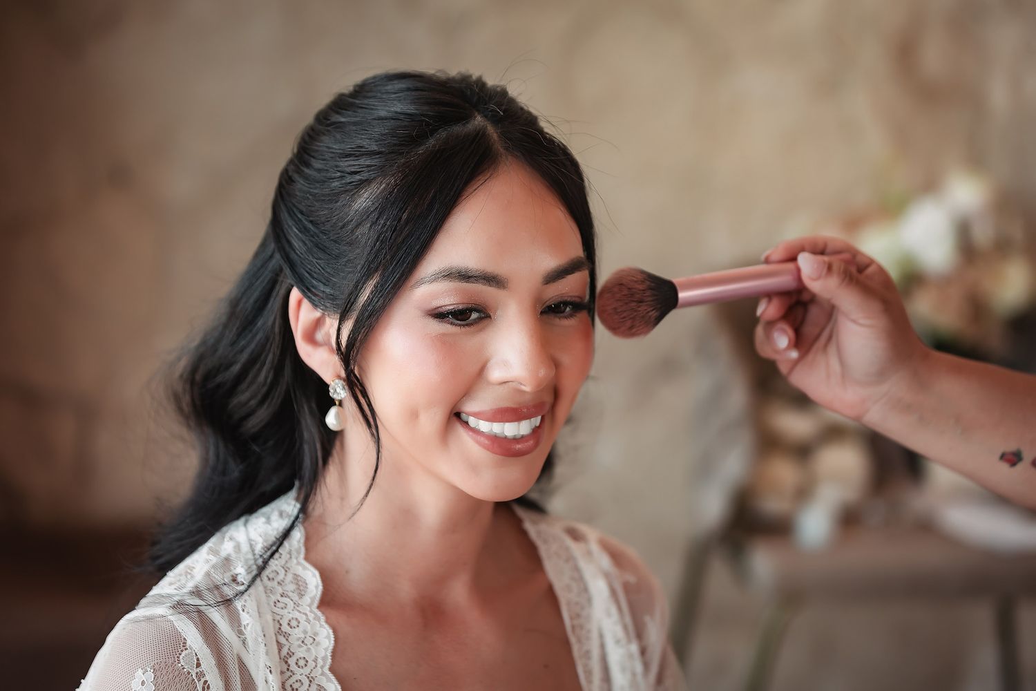 Close-up shots of a bride getting her makeup professionally done during wedding preparations.