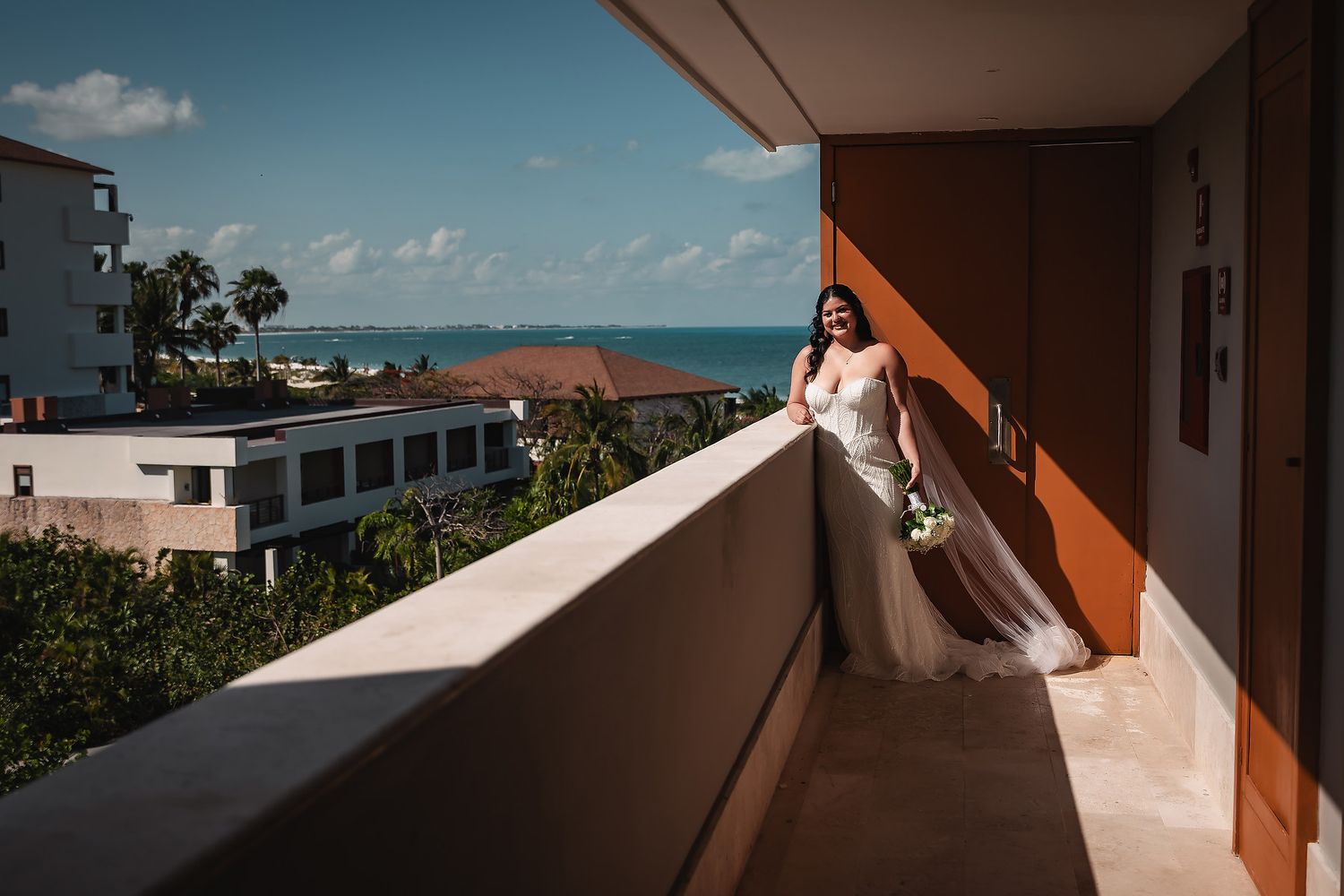 Panoramic view of a tropical beachfront balcony with orange architectural details.