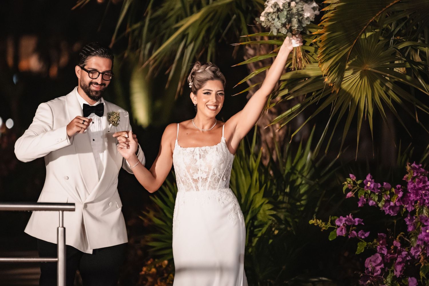 A celebratory moment during a wedding toast at an outdoor tropical venue.
