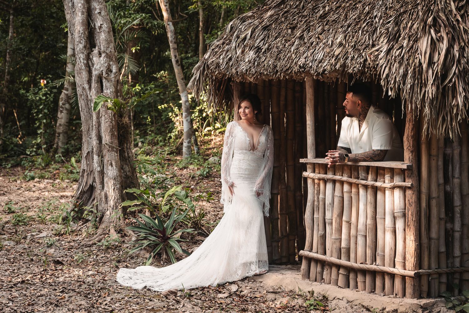 Rustic thatched-roof structure nestled among tropical trees and vegetation.