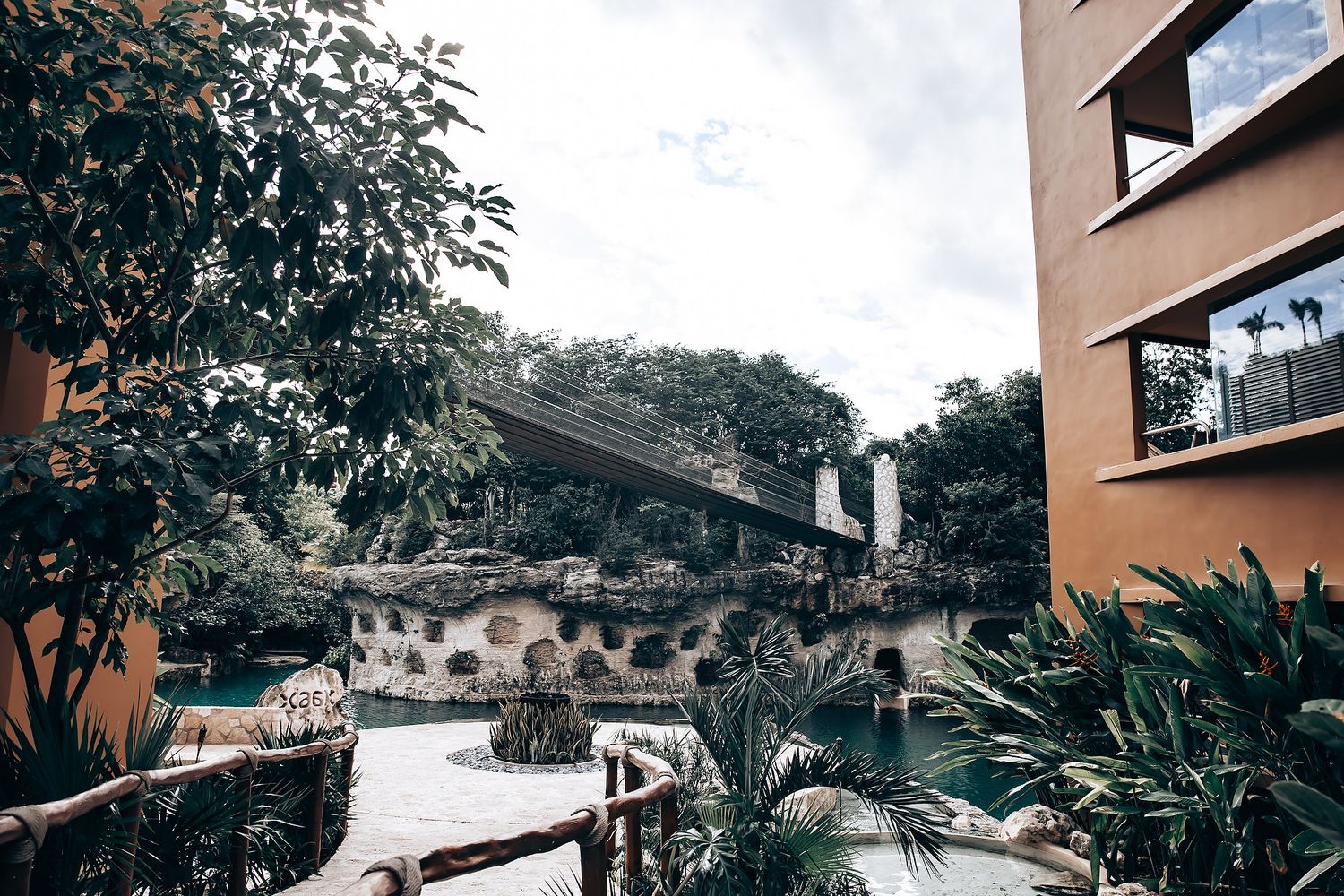 Outdoor wedding venue with stone walls and lush tropical landscaping.