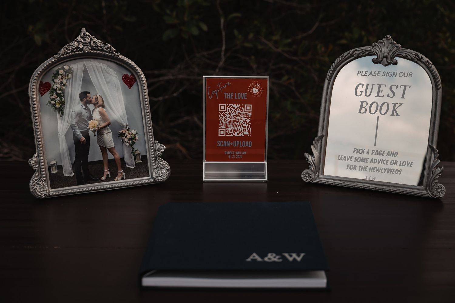 Wedding guest book display with couple photo frame, QR code sign, and navy monogrammed A&W book.