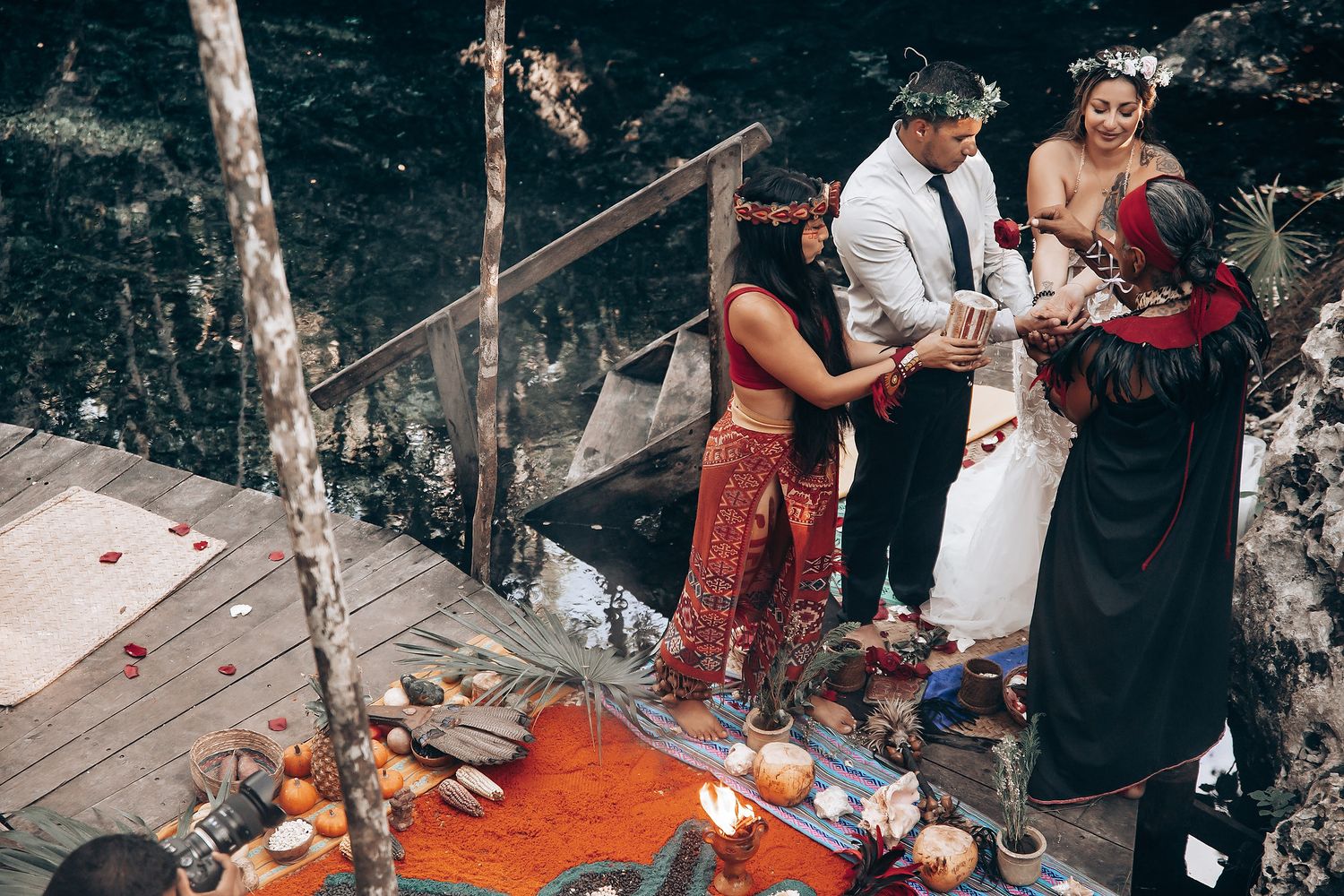 A nature-inspired wedding ceremony with bohemian decor and orange accents in a forest setting.