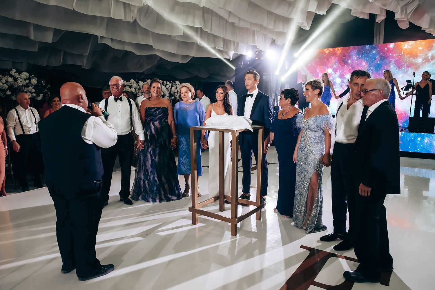 Wedding reception dance floor with guests celebrating under draped fabric ceiling.