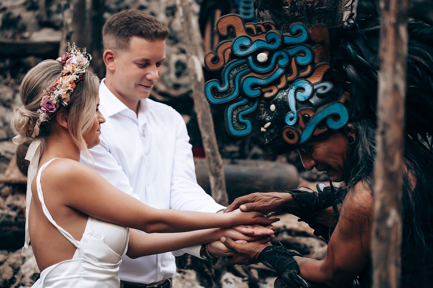 Wedding couple dancing together in front of a decorative blue wall in an outdoor garden setting.