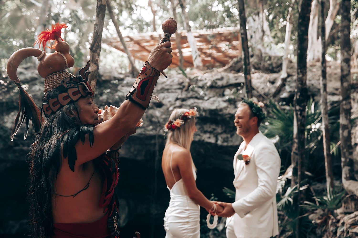 Wedding attendees dance and celebrate in an outdoor wooded setting.