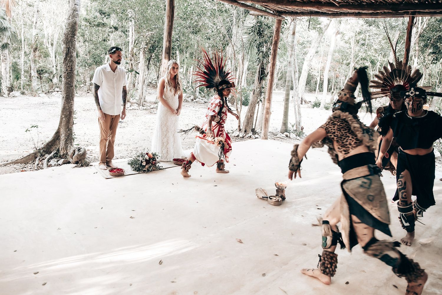 Traditional Mayan dancers perform ceremonial ritual in outdoor jungle setting.
