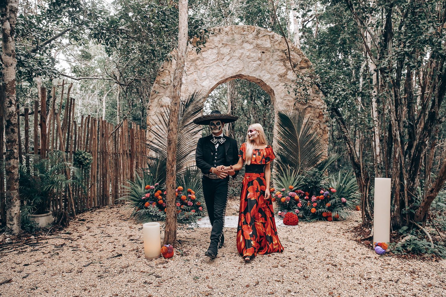 Moody forest photoshoot with figures walking among trees in gothic and vintage-inspired attire.
