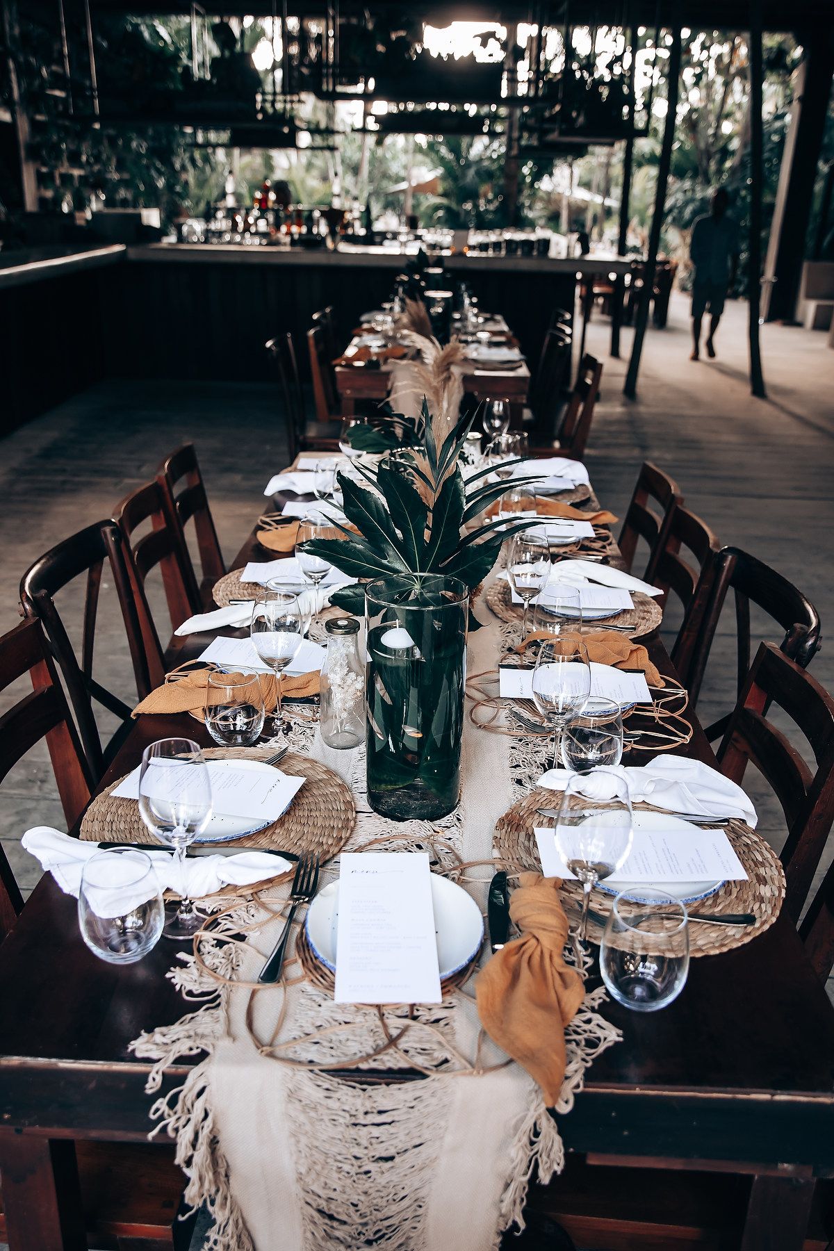 Elegant wedding reception tables set with white linens and place settings in a restaurant setting.