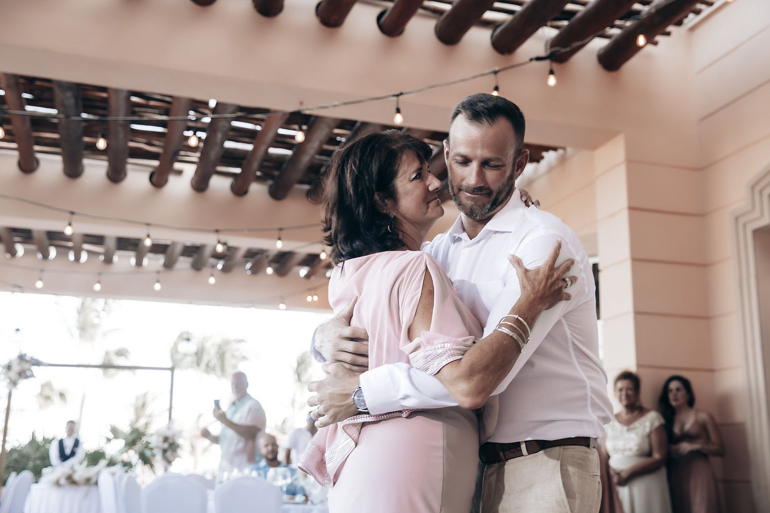 A couple embracing and dancing at what appears to be a wedding reception.