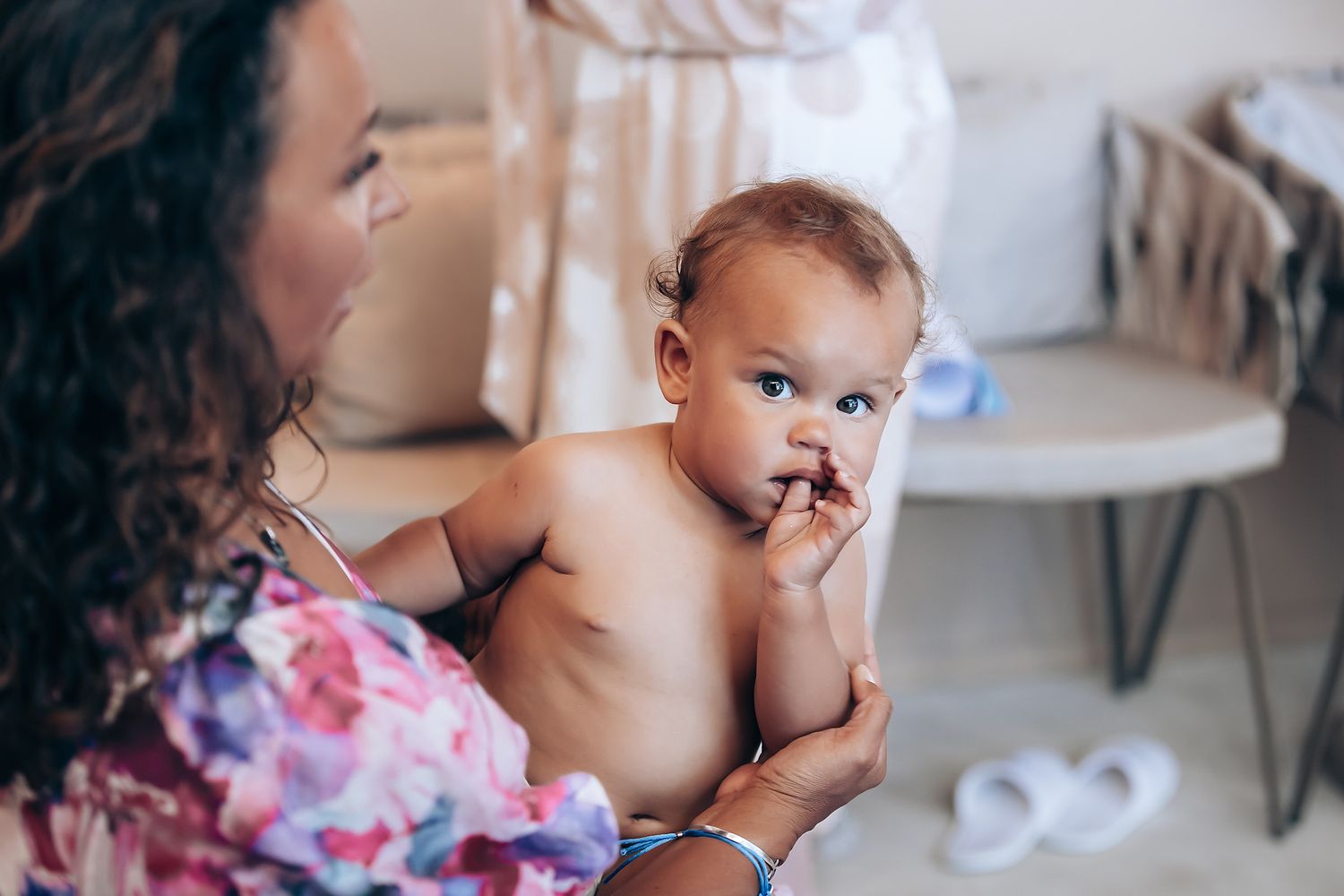 A series of candid moments showing a baby and caregiver during feeding time in a soft-lit interior setting.