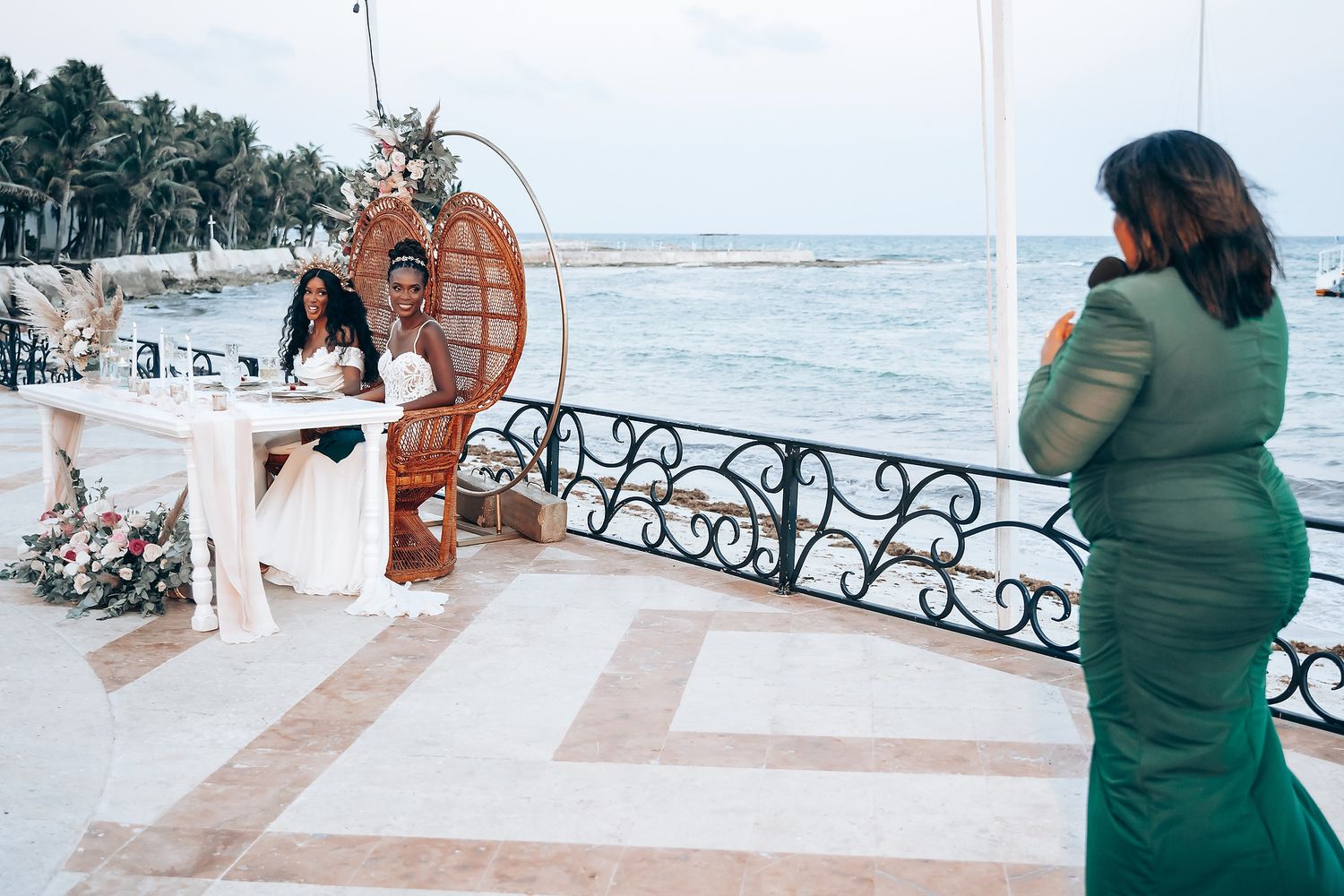 Wedding guests enjoying celebrations on an oceanfront terrace.