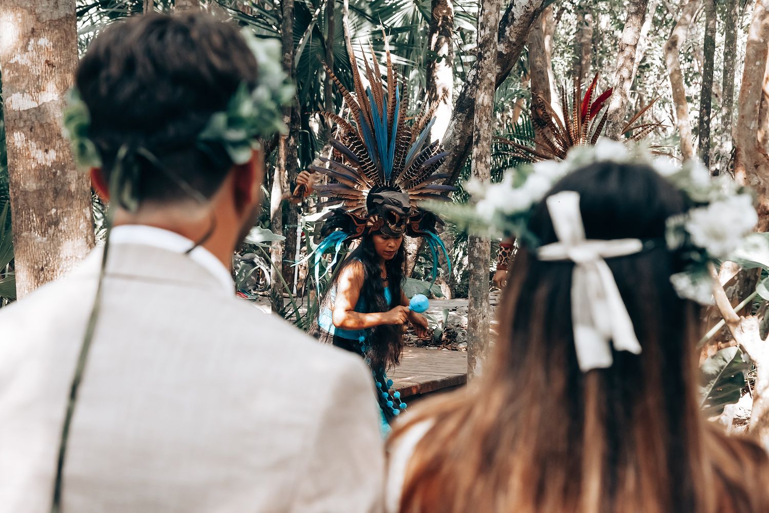 Natural sunlight filters through trees during an outdoor wedding ceremony.
