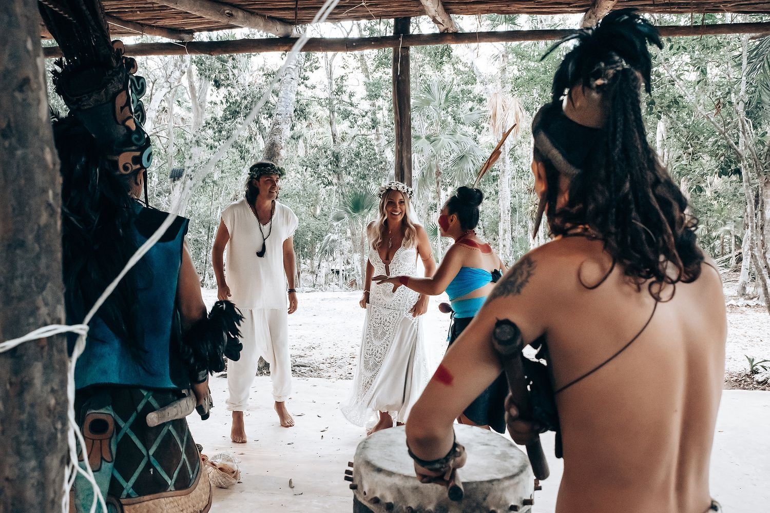 People gathered under a rustic covered patio area for an outdoor social gathering.