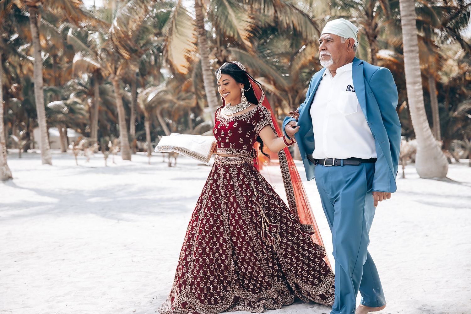 Wedding guests in formal attire walking through outdoor venue with burgundy dresses.