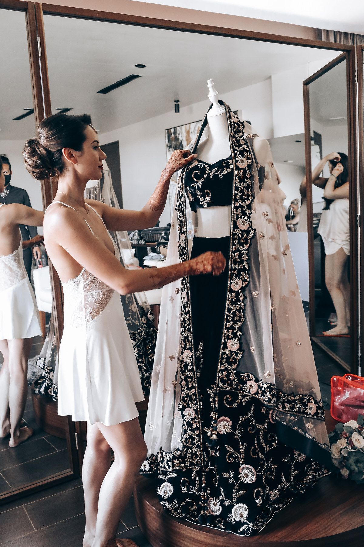 A sequence of photos showing someone in a white dress taking mirror selfies in a dressing room with floral wallpaper.