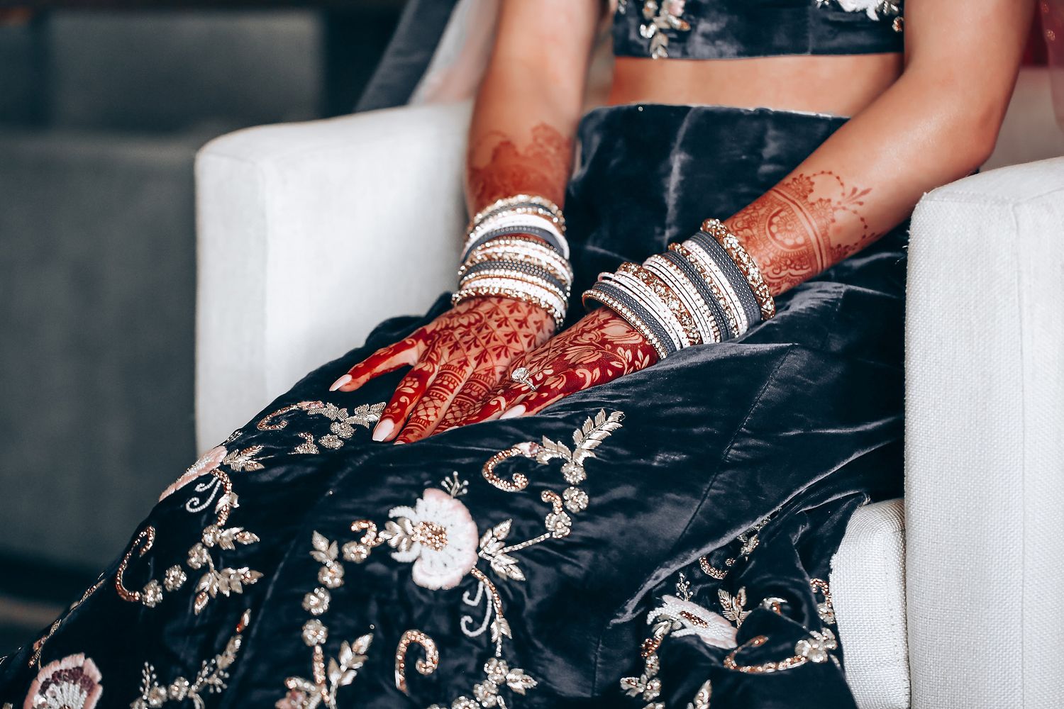 Detailed view of traditional Indian bridal hands adorned with bangles and mehndi designs.