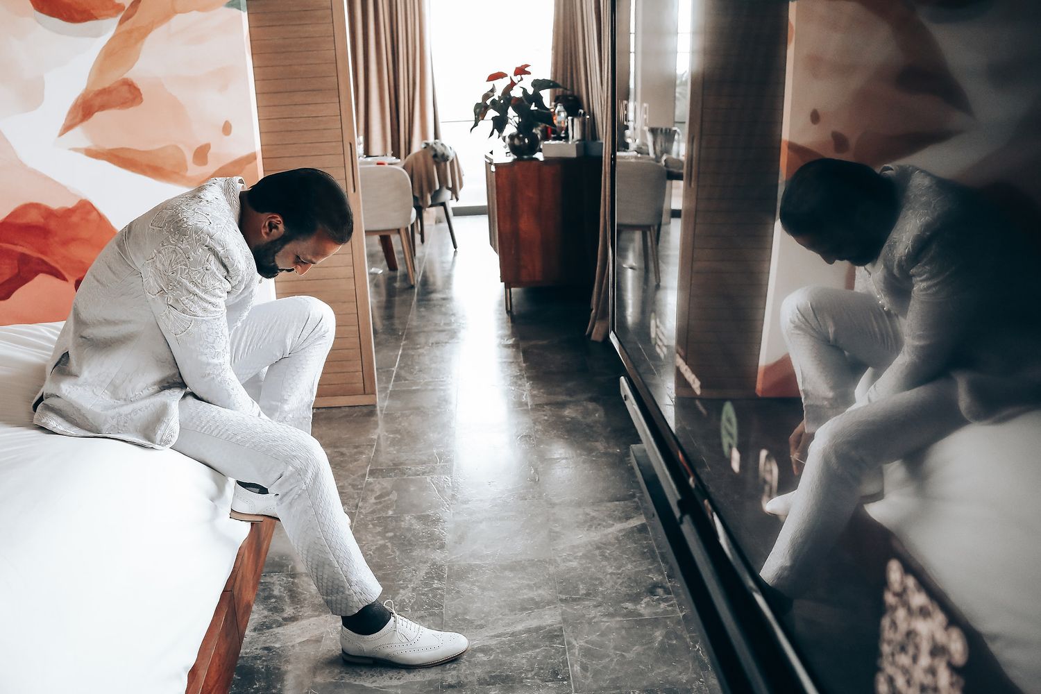 Medical professional in protective gear performs disinfection and sanitization in a long hallway during pandemic response.