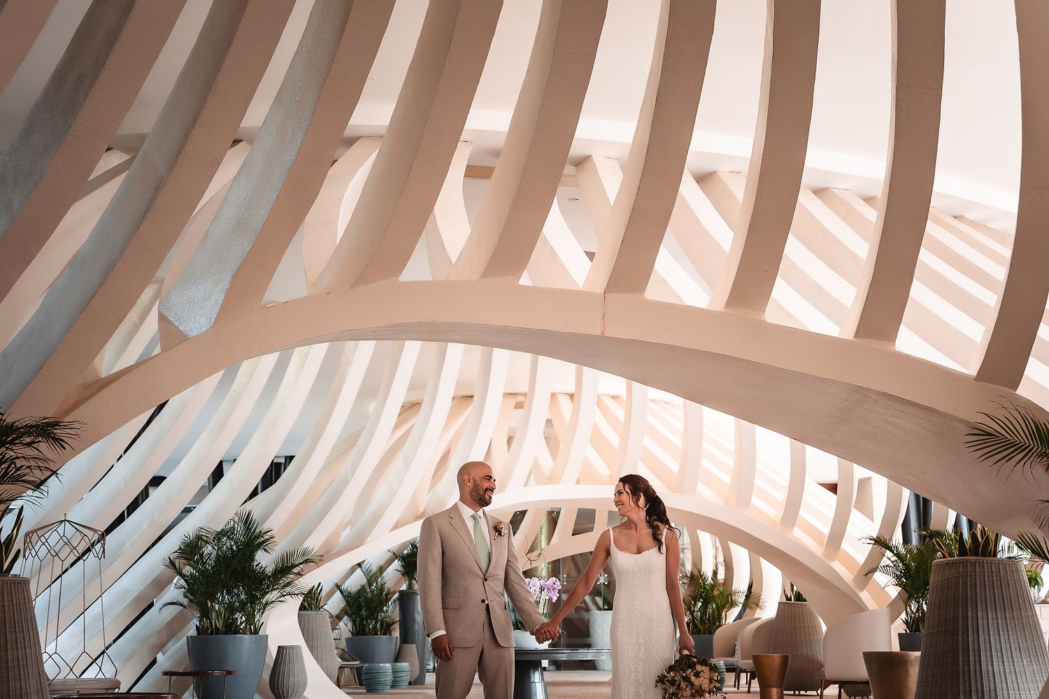 Elegant architectural interior with curved white beams creating a modern ribbed ceiling design in natural lighting.