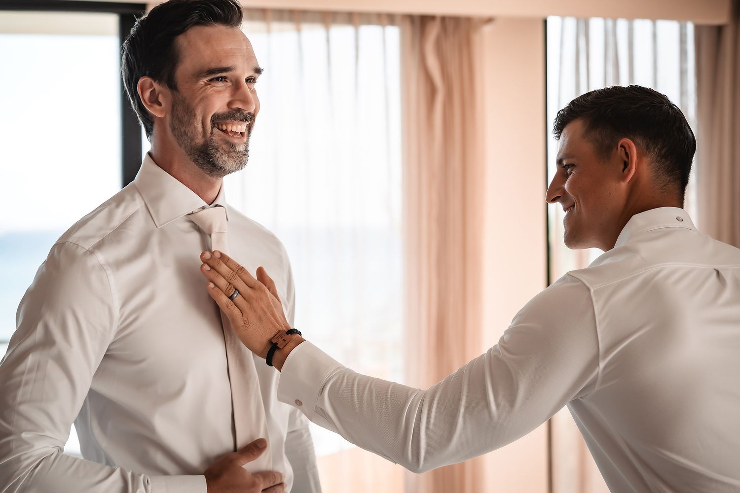 People in formal attire interacting in a bright indoor setting.