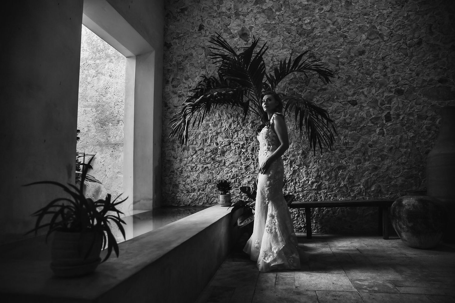 Black and white artistic wedding photos showing silhouette against textured stone wall and window light.