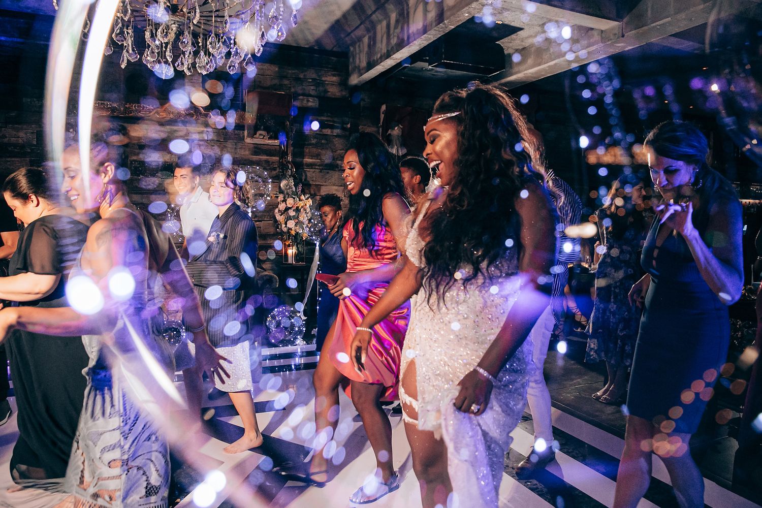 Energetic crowd dancing and enjoying live music at a nightclub with colorful lighting and atmospheric effects.