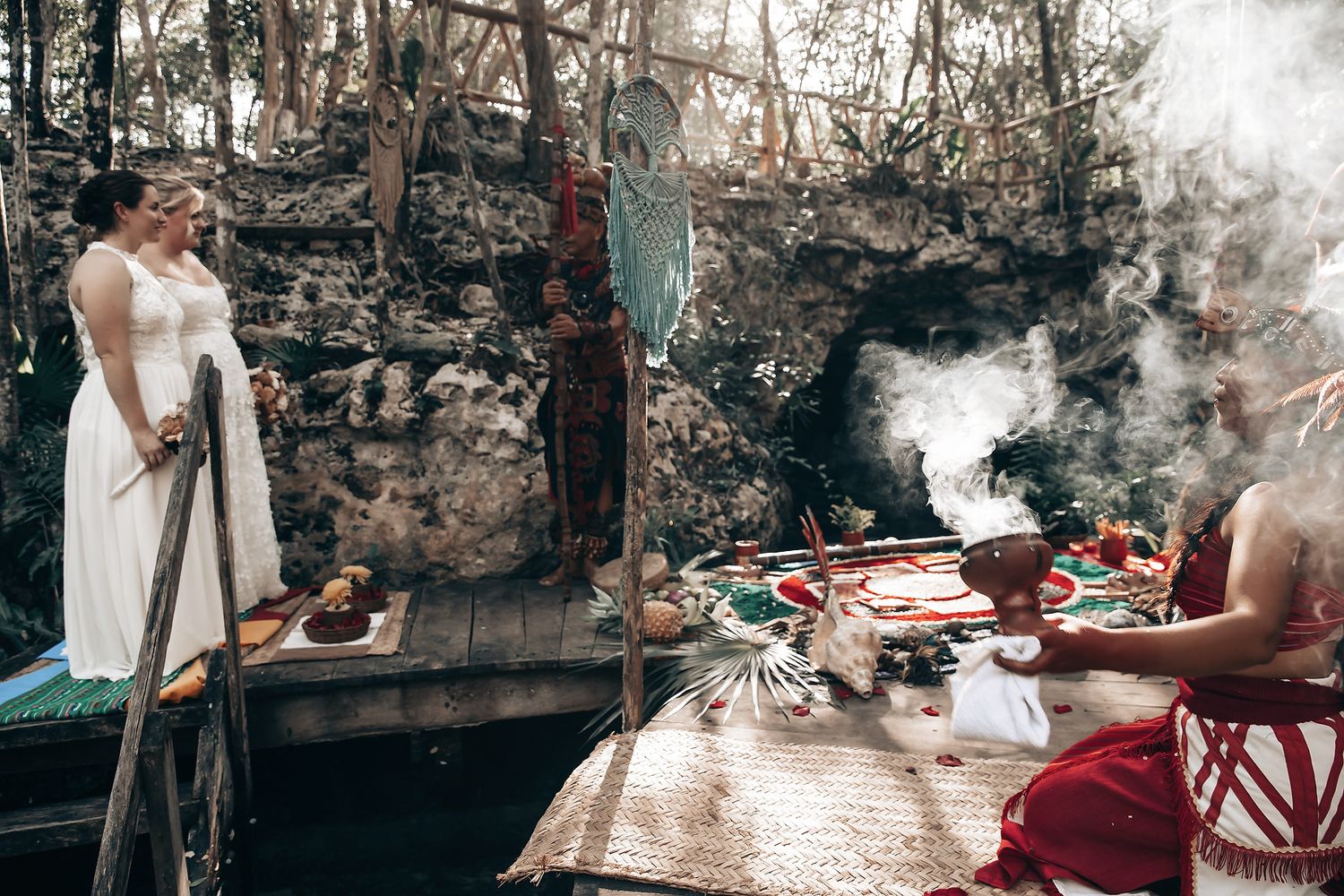 A group of people gathered around a fire in an outdoor, rustic setting with various objects and decor.