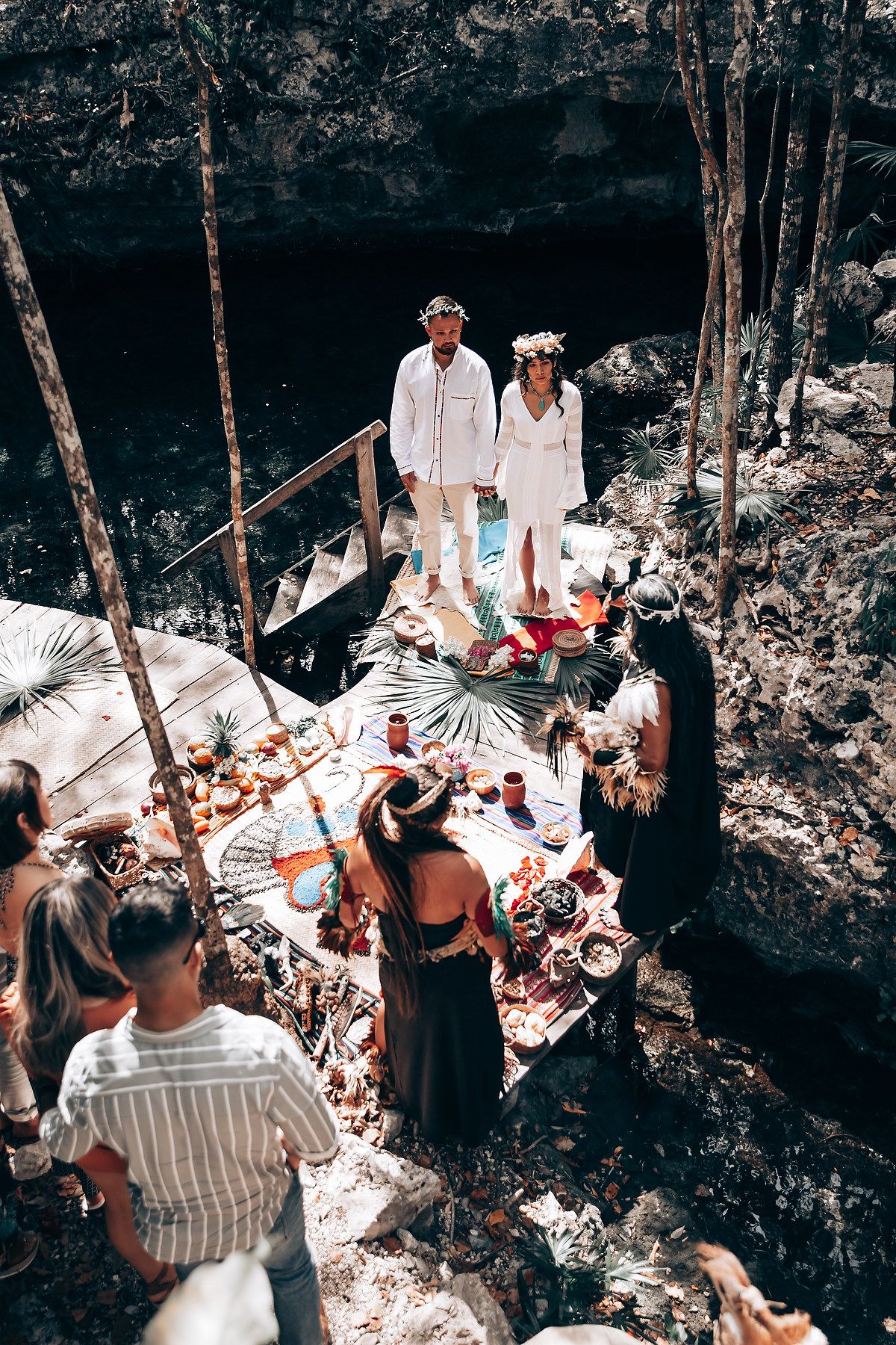 People gathered in a wooded outdoor setting for what appears to be a traditional ceremony or celebration.
