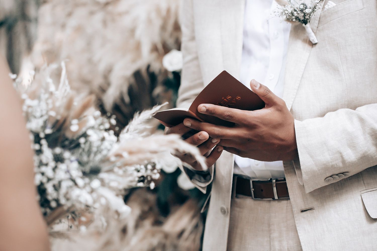 Close-up of wedding ceremony details with white floral arrangements in a forest setting.