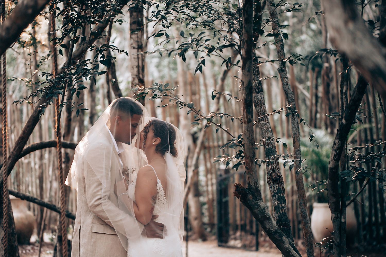 Romantic forest wedding photoshoot with soft natural lighting filtering through trees.