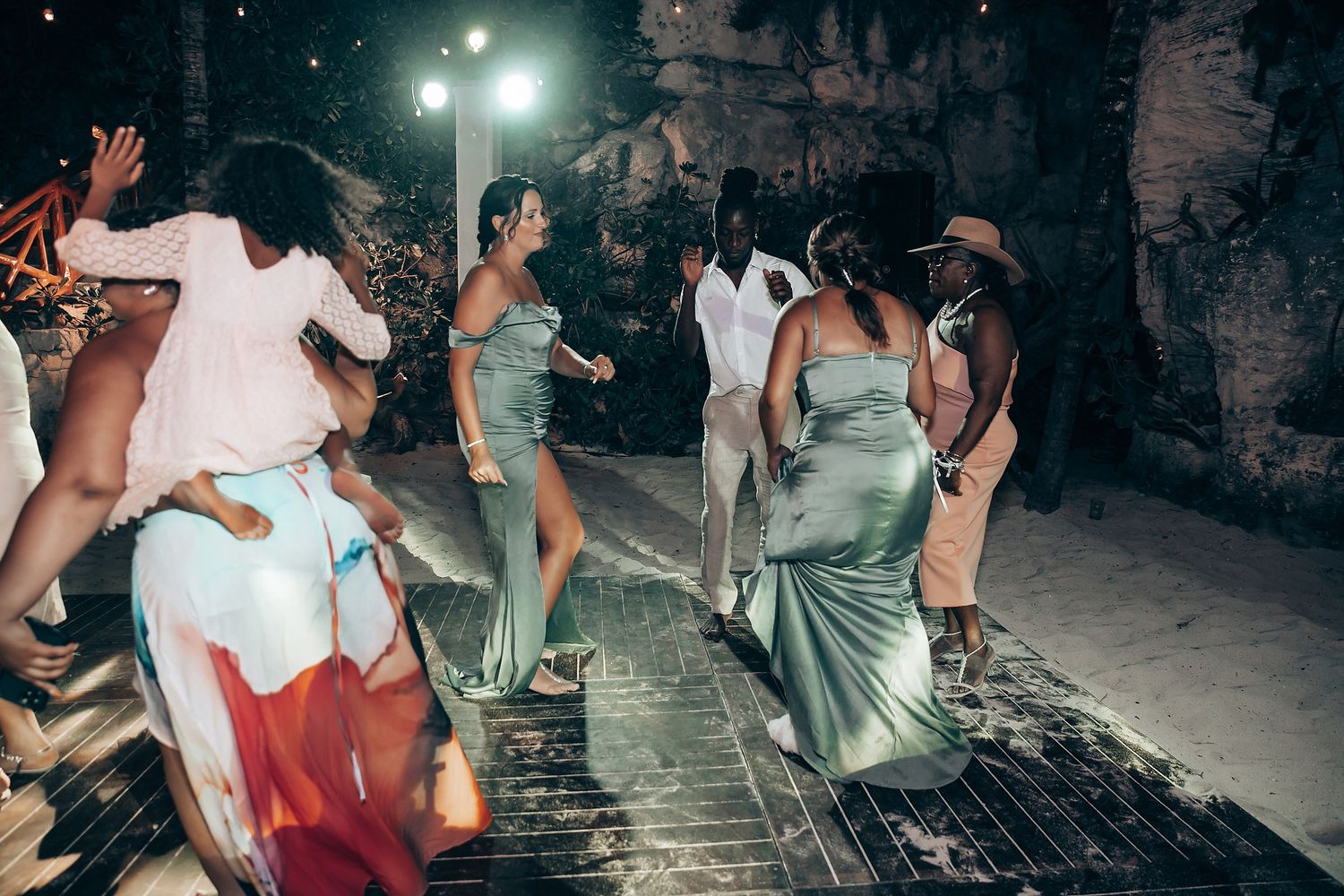 Wedding reception dance party in a cave-like venue with atmospheric lighting.