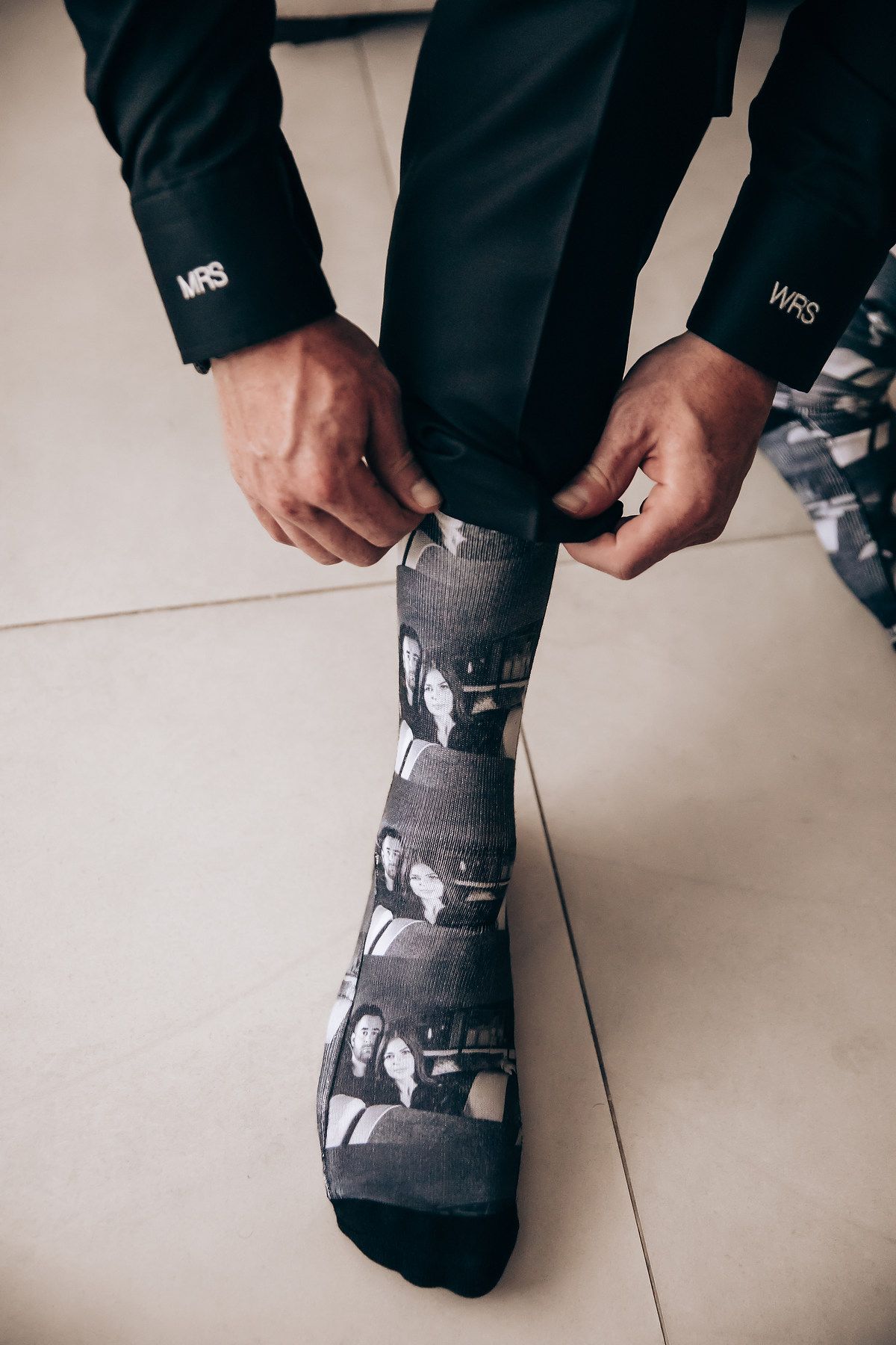 Series of black and white socks with graphic prints being adjusted on feet against a light background.