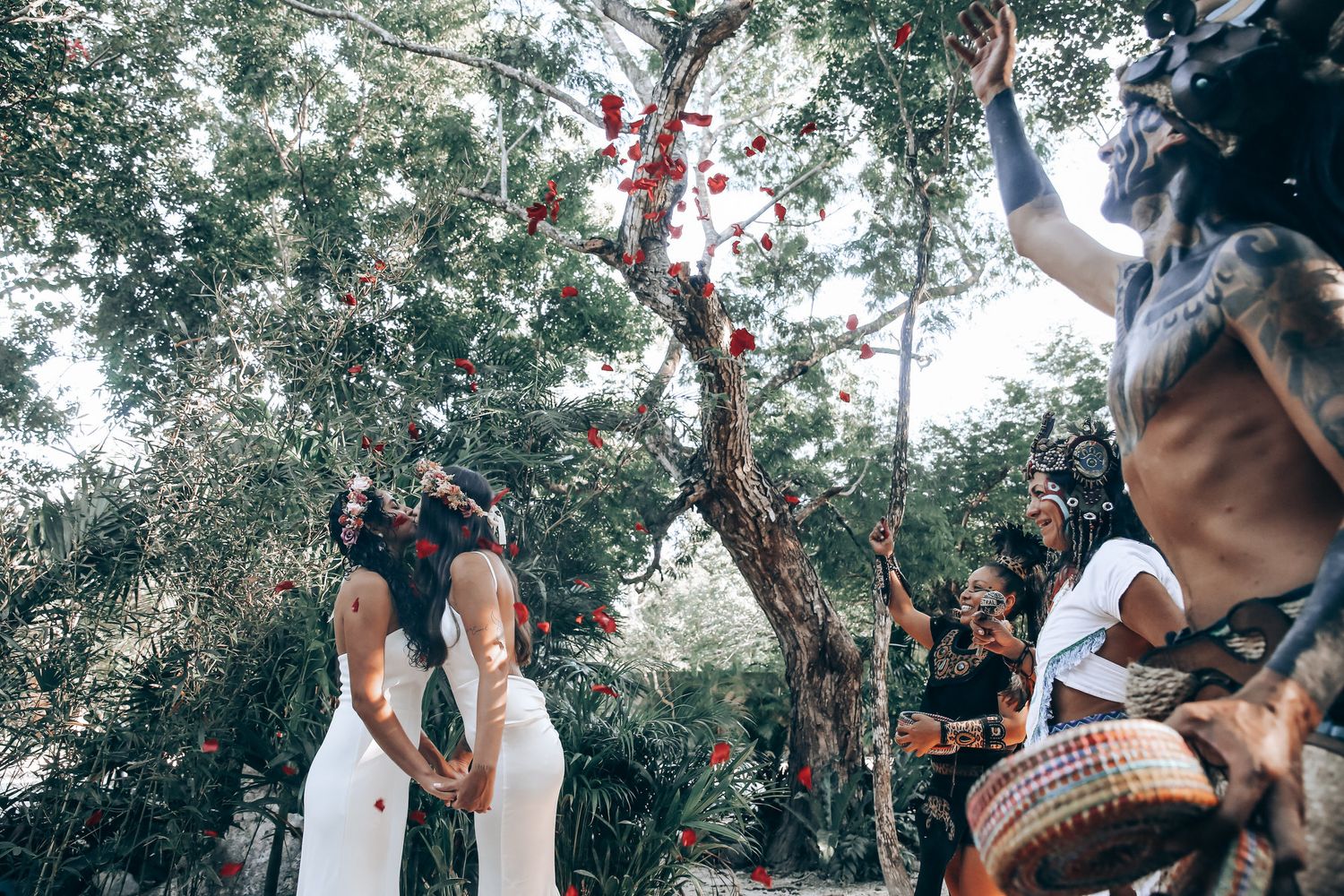 A couple shares an intimate moment in a lush garden setting with natural lighting and greenery.