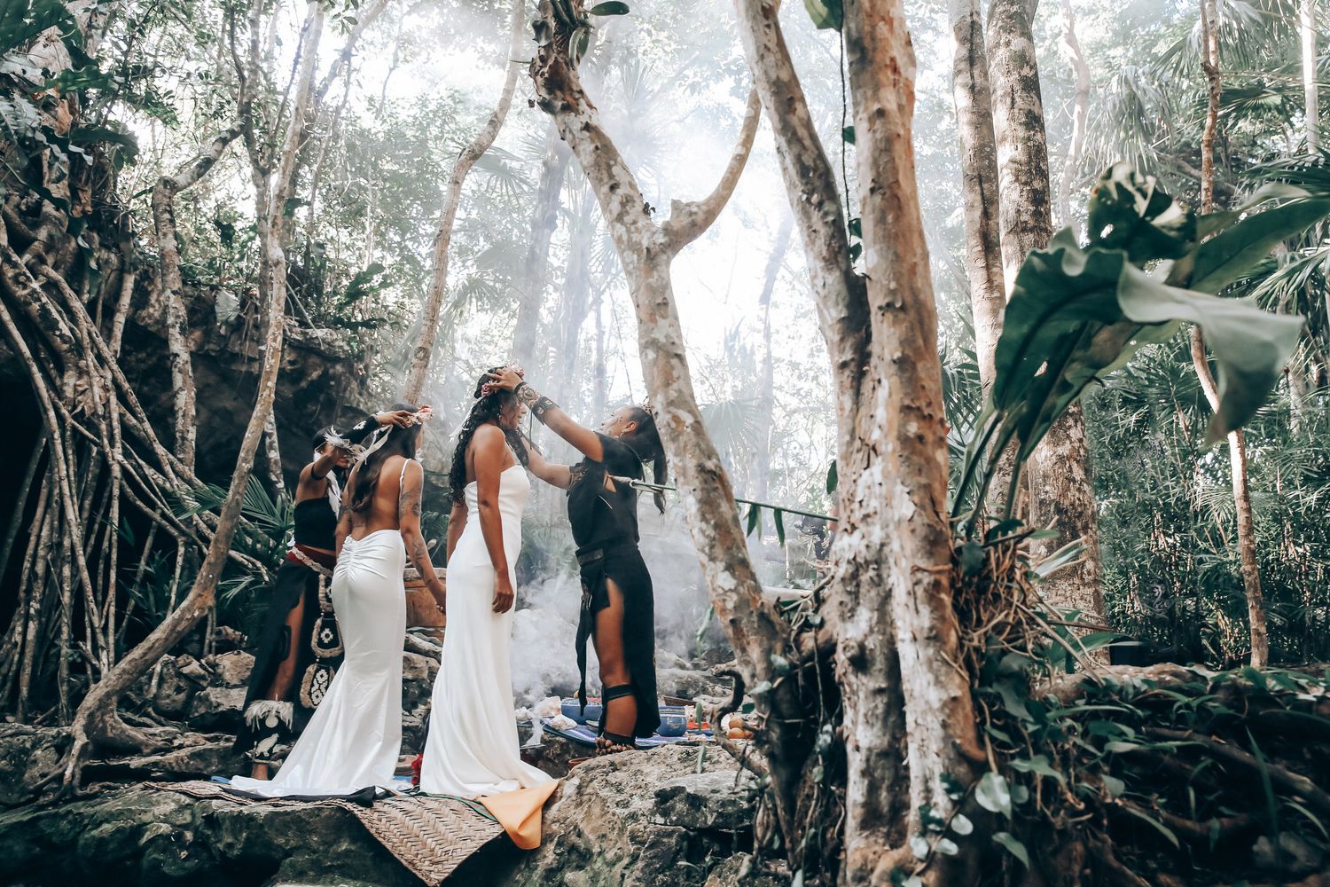People walking through a scenic forest path with tall trees and dappled sunlight creating a dreamy atmosphere.