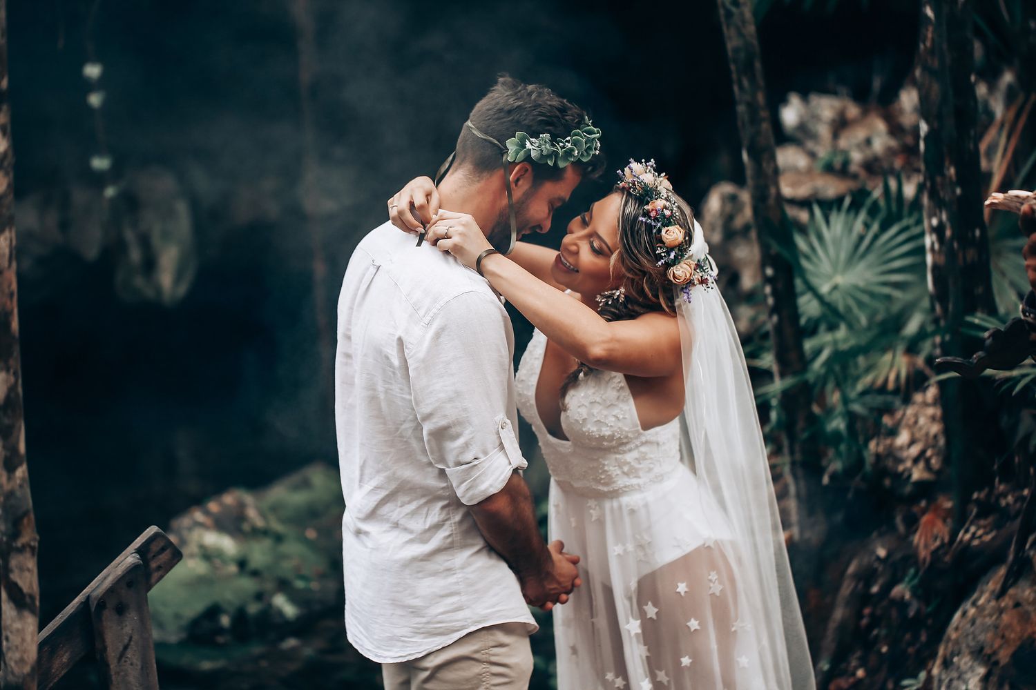 Intimate wedding ceremony moment in a lush tropical garden setting.