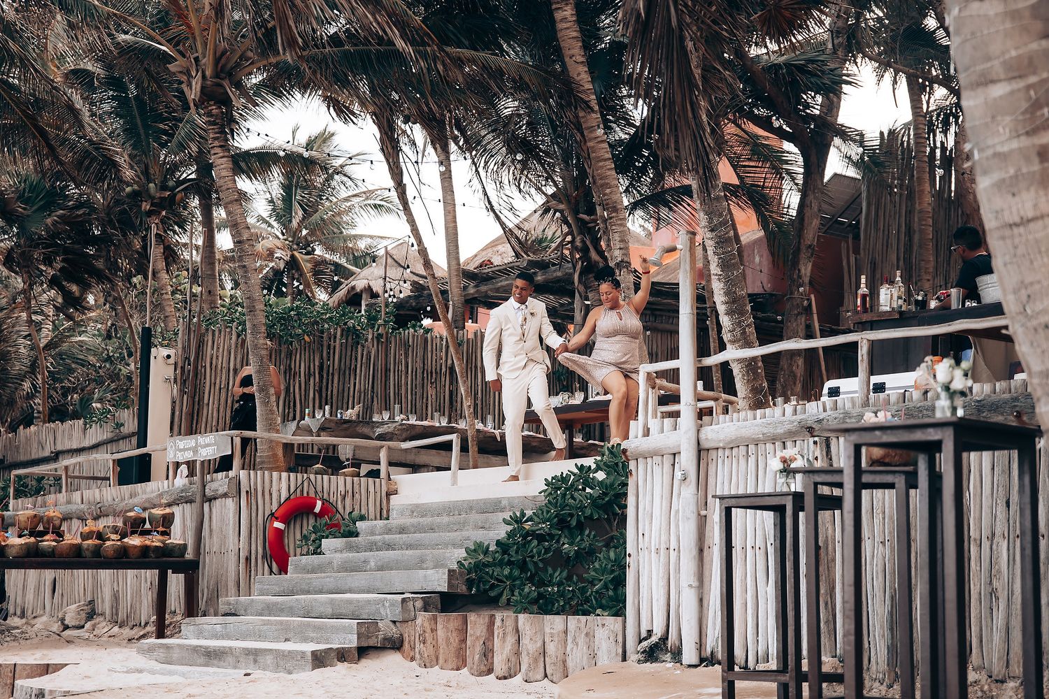 Beachside wedding venue with wooden fencing and tropical palm trees.