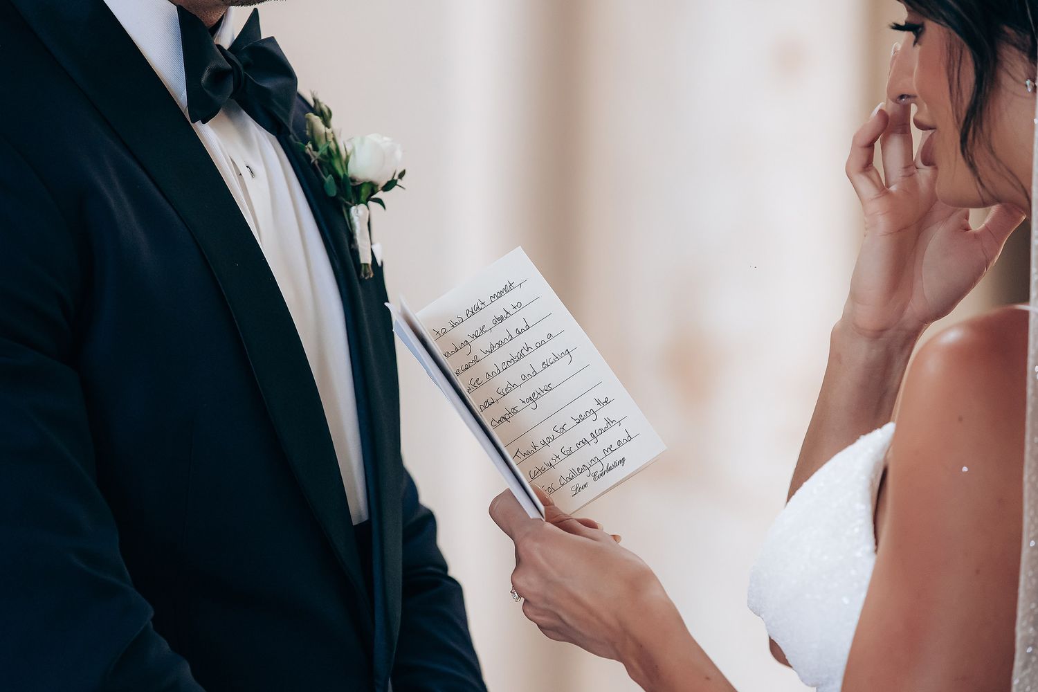 Bride and groom reading handwritten vows to each other during an intimate wedding ceremony.