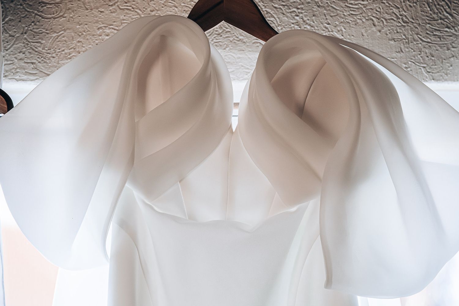 White sheer curtains hanging on a rod cast soft shadows and create an elegant window treatment effect.