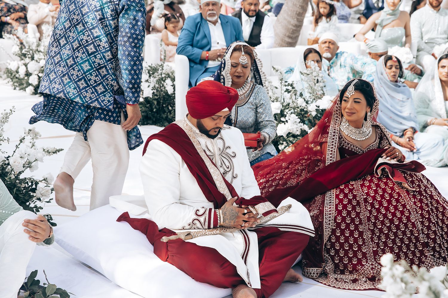 Wedding guests enjoying celebration in outdoor venue with tropical decor.
