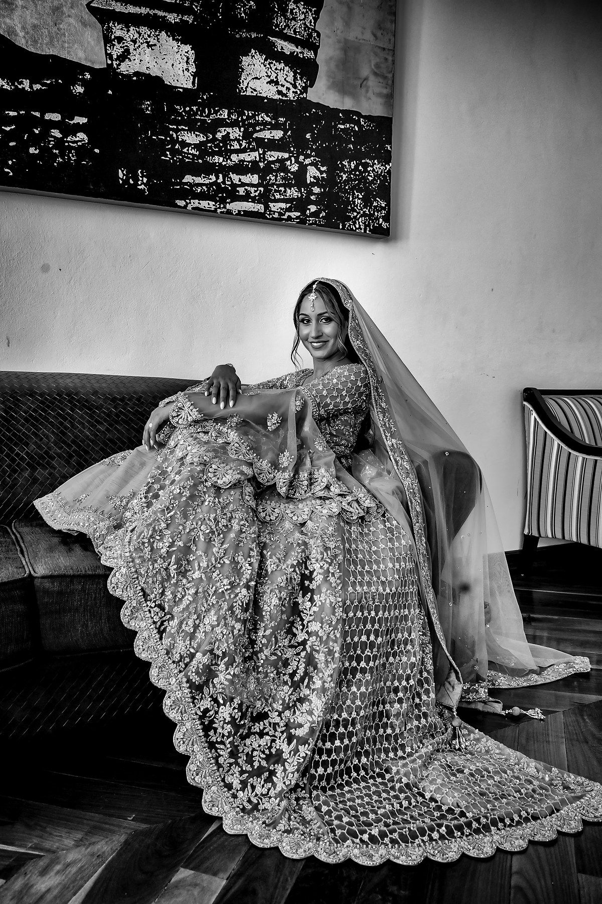 Black and white photo showcasing the dramatic flow of an embellished wedding gown.