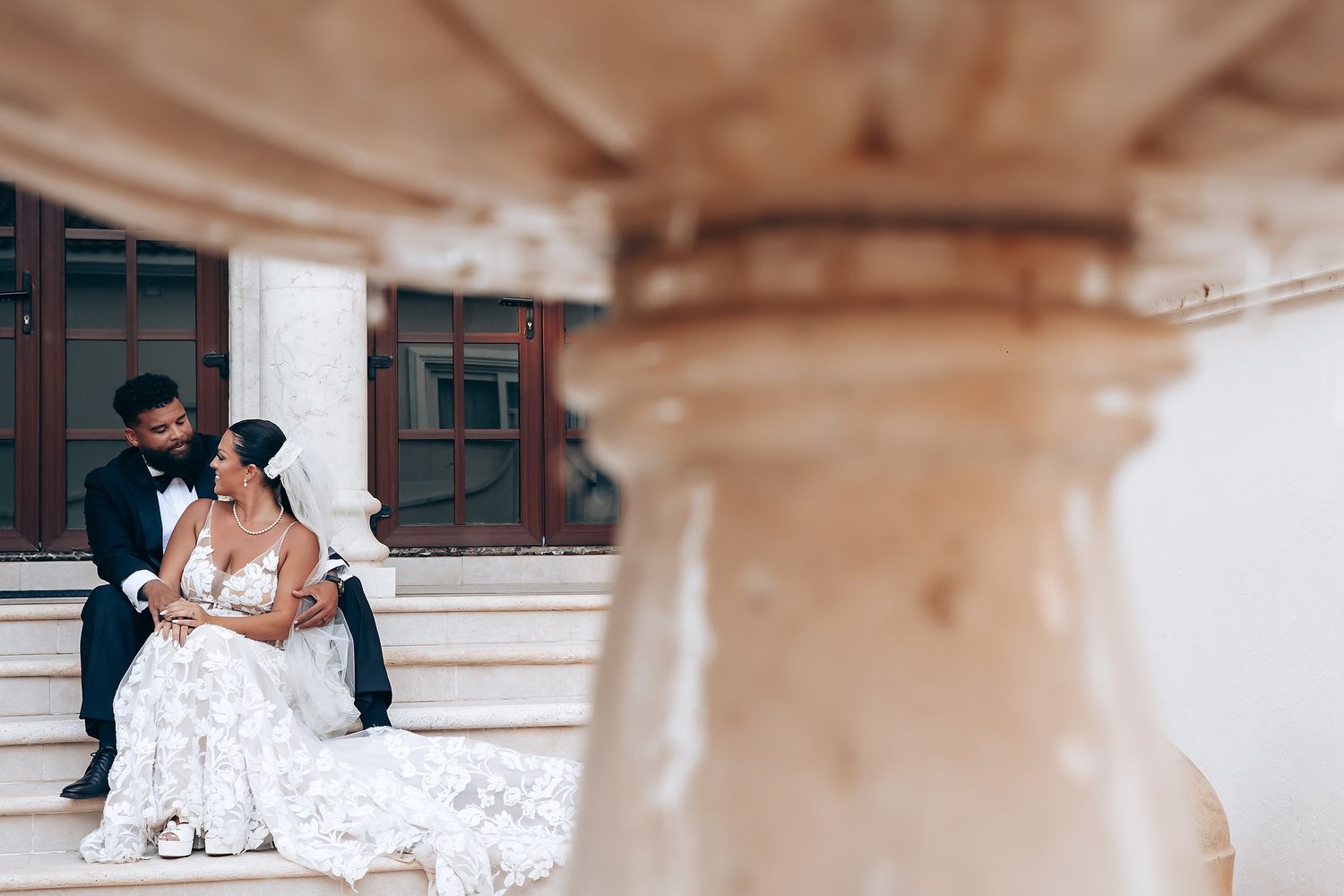 Intimate beachside wedding ceremony with white decor and natural lighting.